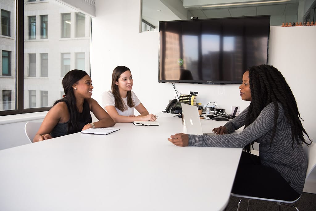 Three women sitting around a table discussing