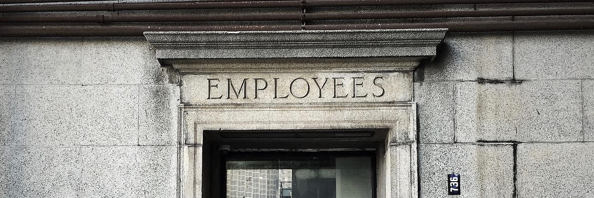 An entrance with "employees" written on the door