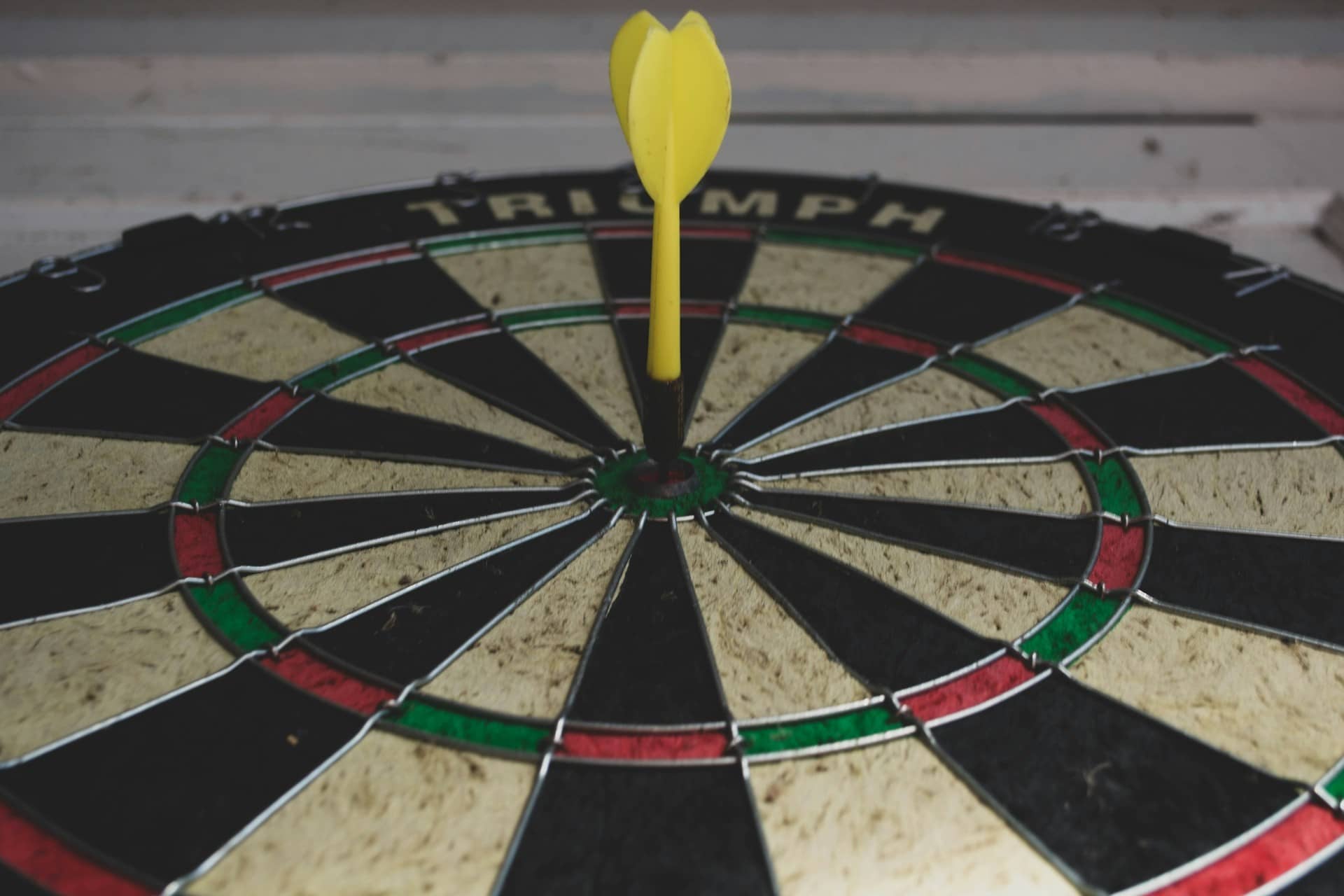 yellow dart pin on bullseye dart board